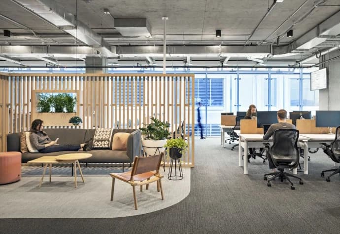 Modern open-plan office with collaborative lounge and workstation areas